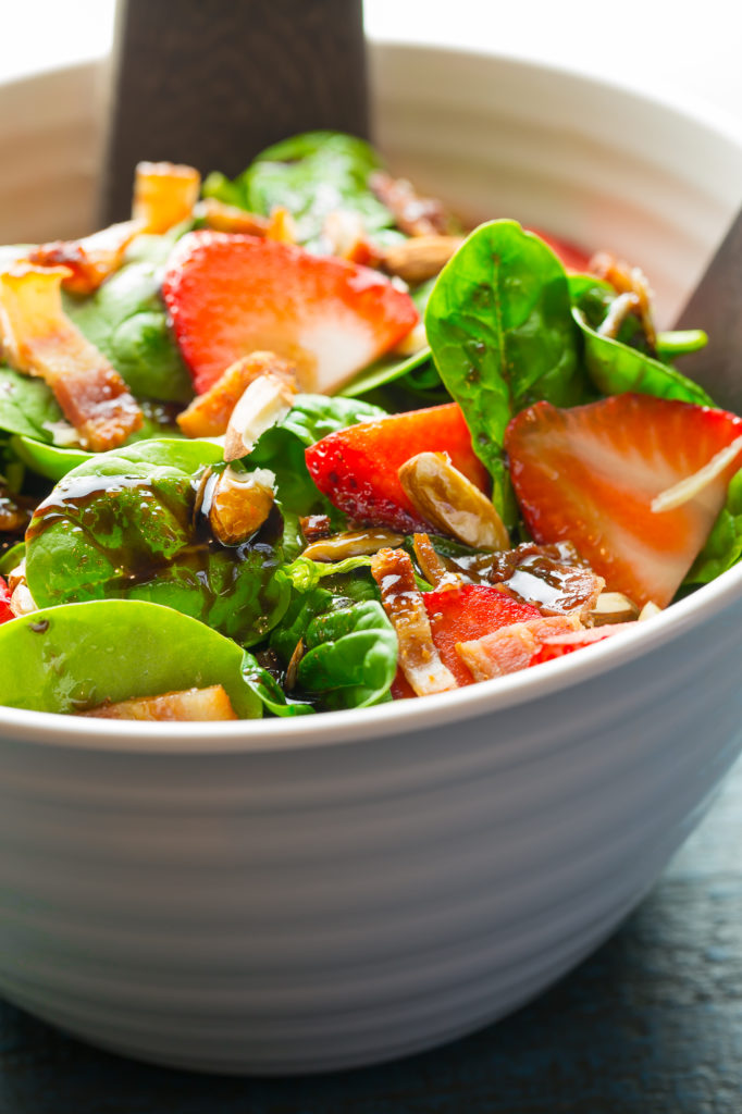 Simple spinach salad in a white bowl