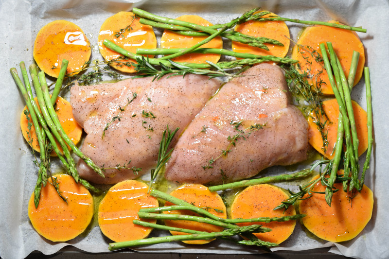 Raw turkey tenderloins with asparagus and butternut squash