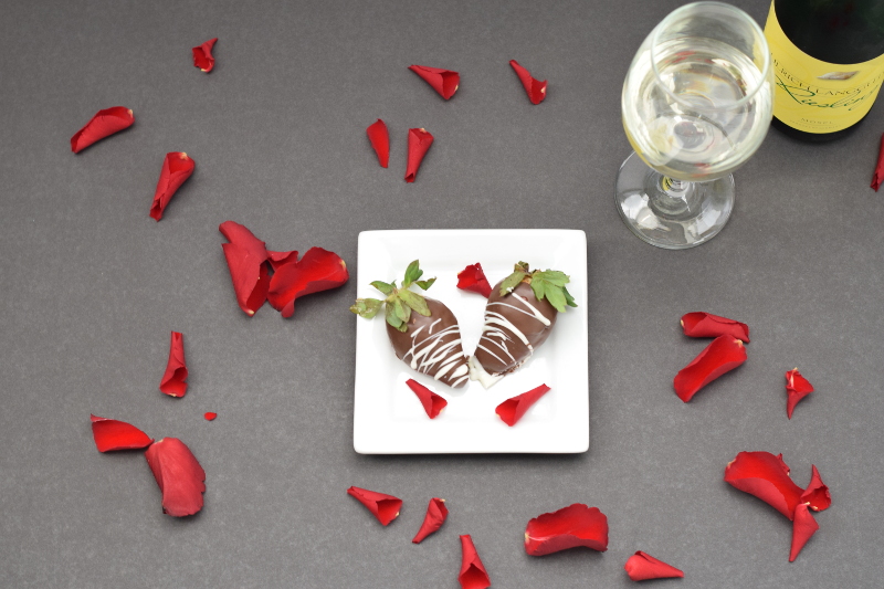 Two chocolate covered strawberries and wine