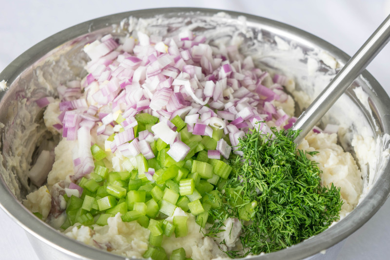mixing potato salad