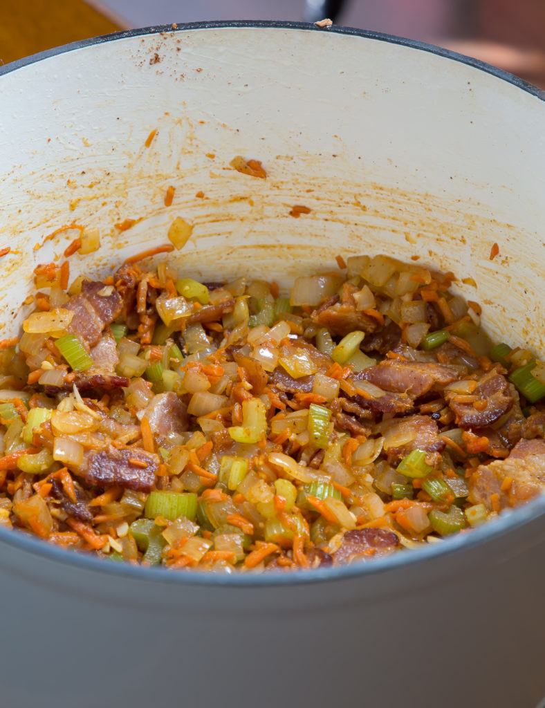 bean and bacon soup in dutch oven with tomato paste