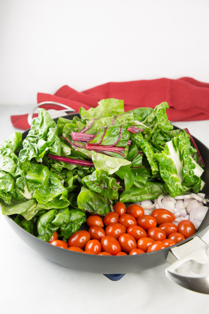 Chard, tomatoes, and shallots in a chef pan