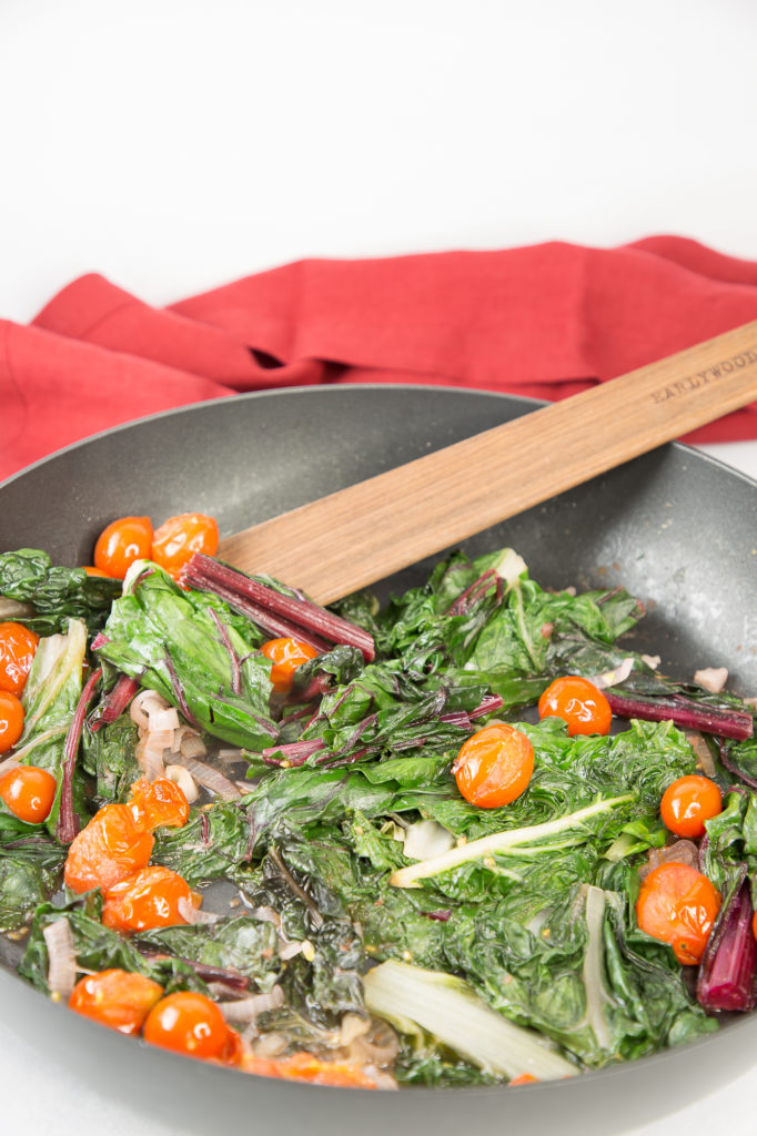 Sautéed chard, shallots, and tomatoes in a chef pan