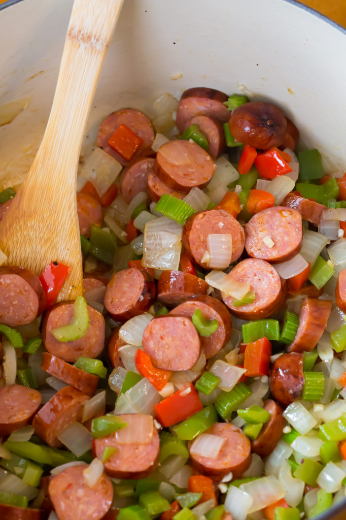 Veggies and andouille sausage sauteeing in a dutch oven